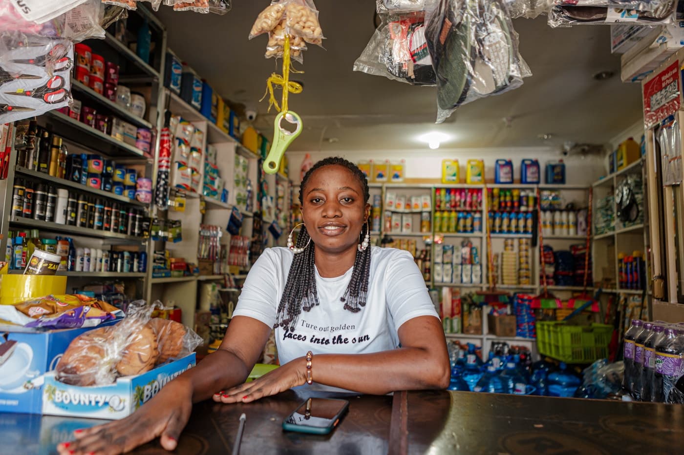 A shop owner behind the counter of her well-stocked neighbourhood store in Dar es Salaam